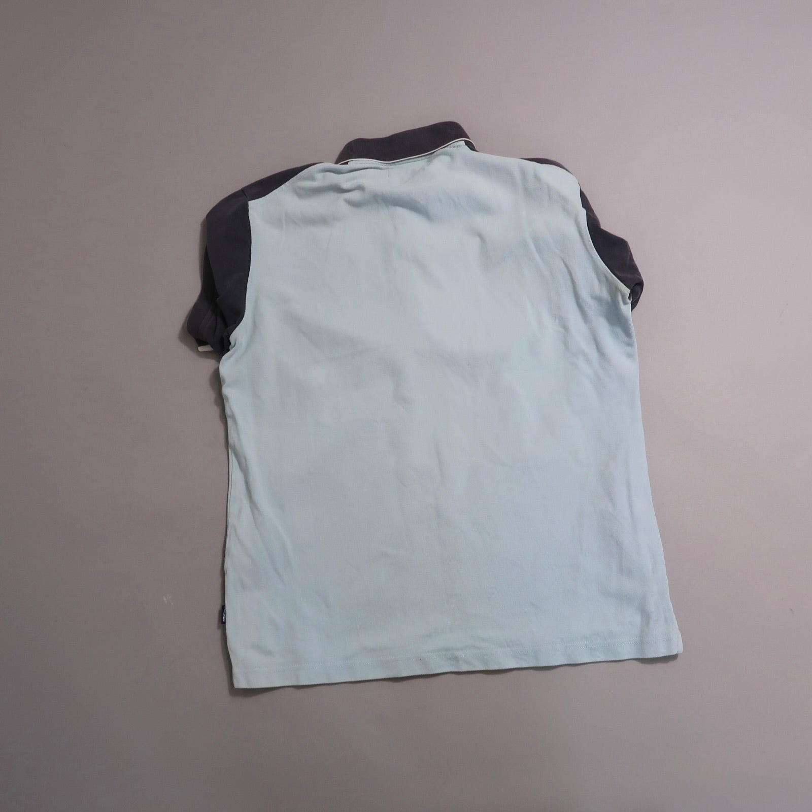 Back view of a light blue and dark gray short-sleeve polo shirt.