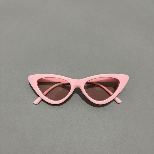 Retro pink cat-eye sunglasses on a gray background.