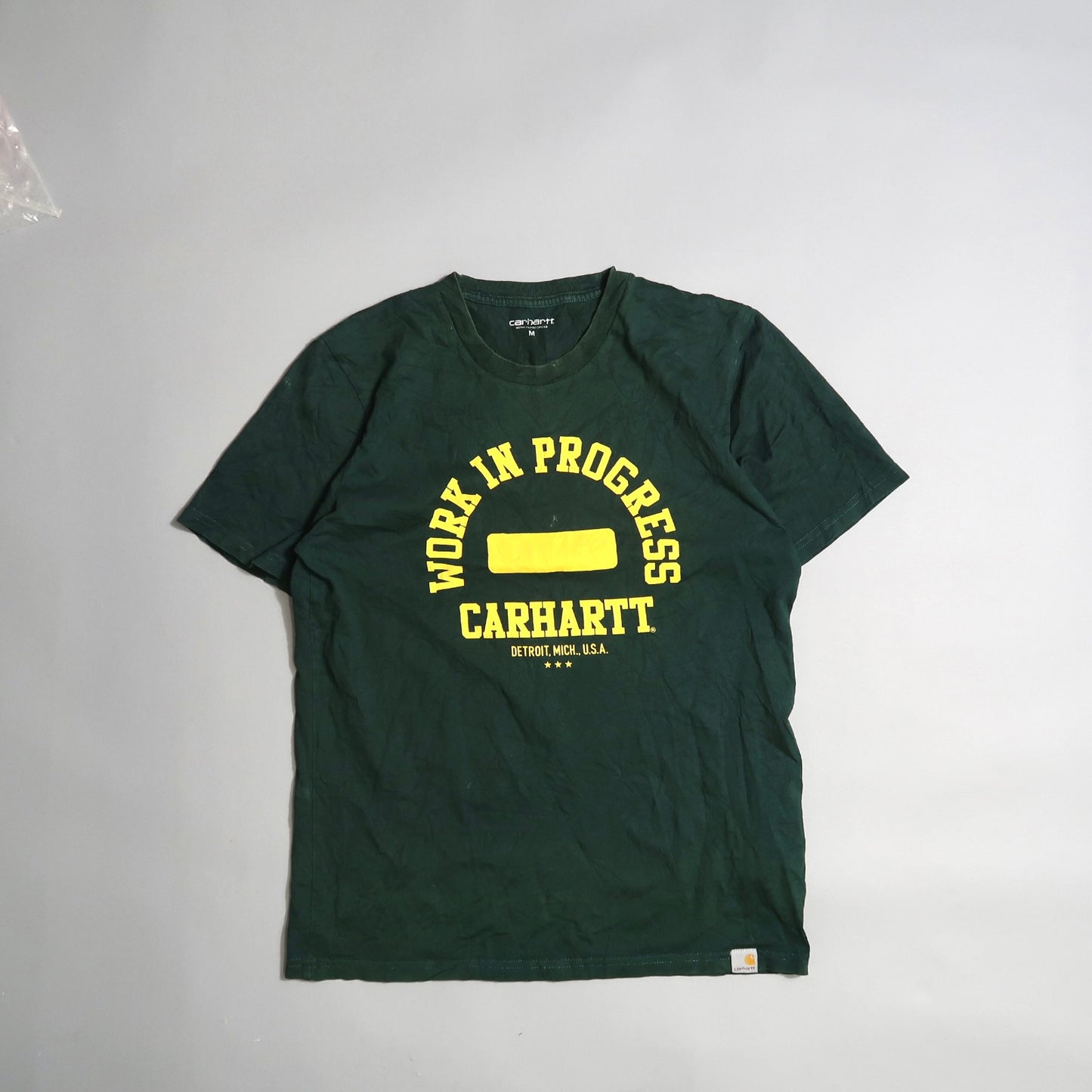Green Carhartt T-shirt with yellow nullWork in Progressnull text.