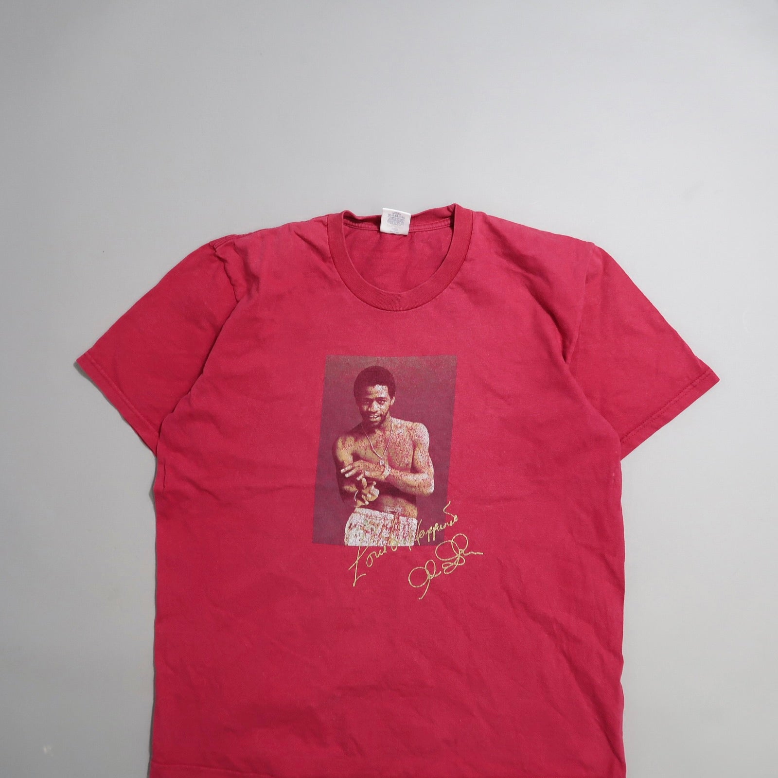 Red t-shirt with a photo of a shirtless man and a signature.