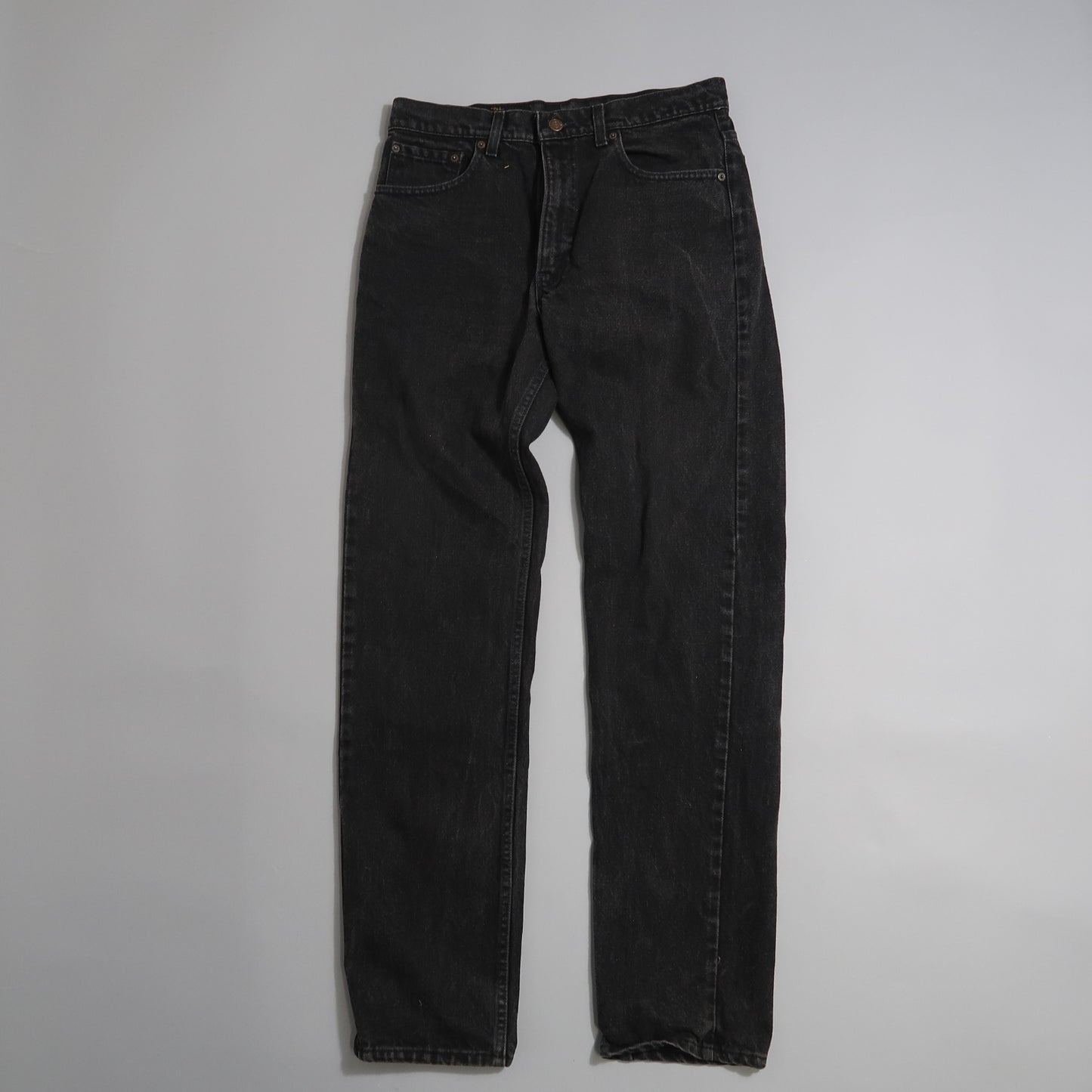 Black denim jeans on a plain white background.