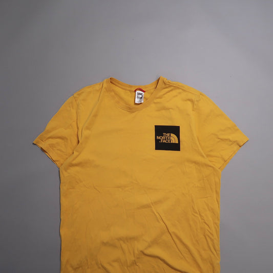 Yellow T-shirt with The North Face logo on the chest, laid flat.