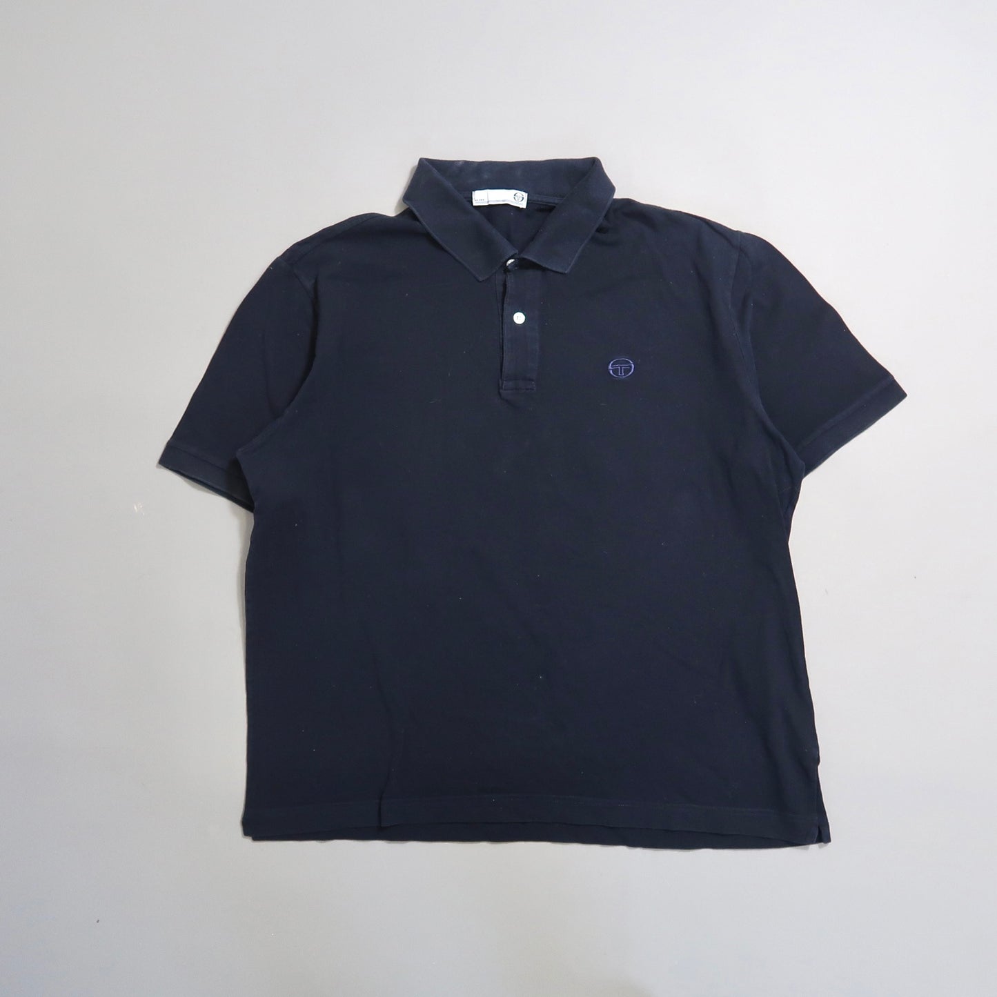 Navy blue polo shirt on a plain background.