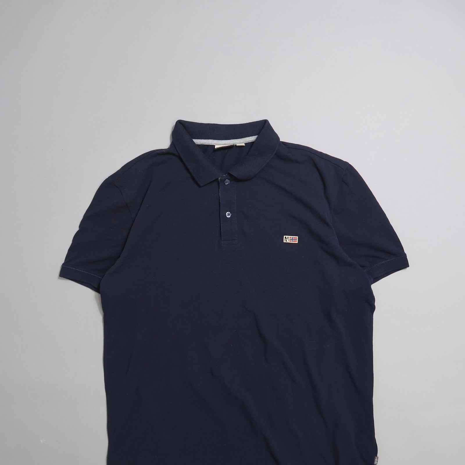 Navy blue polo shirt with a small colorful logo on the chest.