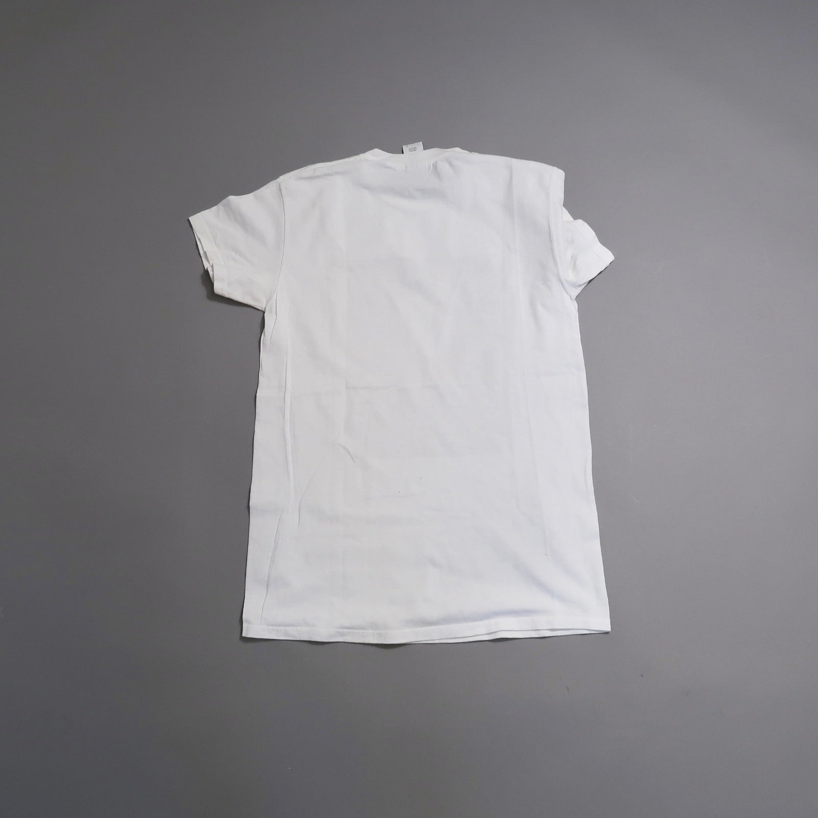 Back view of a plain white T-shirt on a gray background.