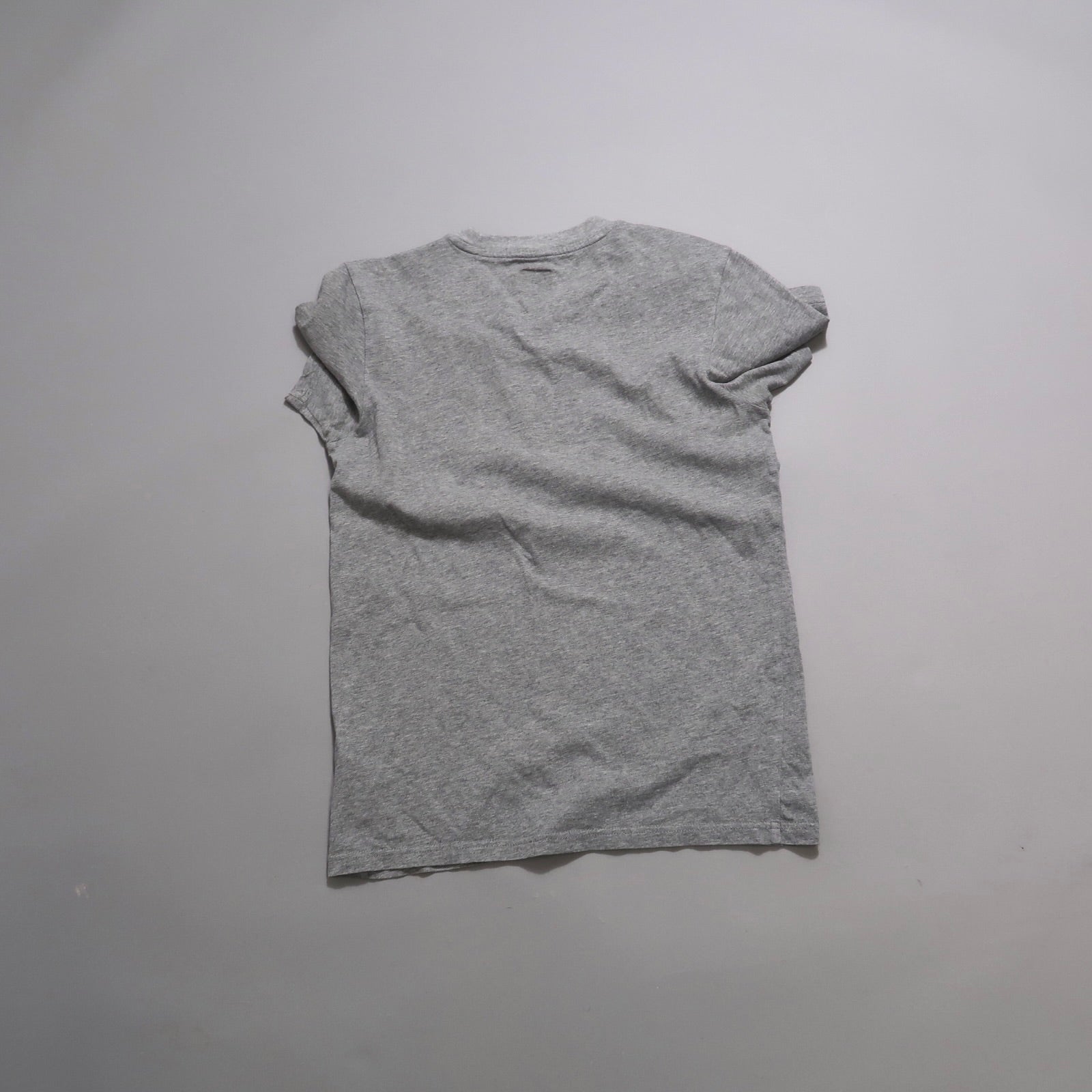 Gray t-shirt lying flat on a light background.
