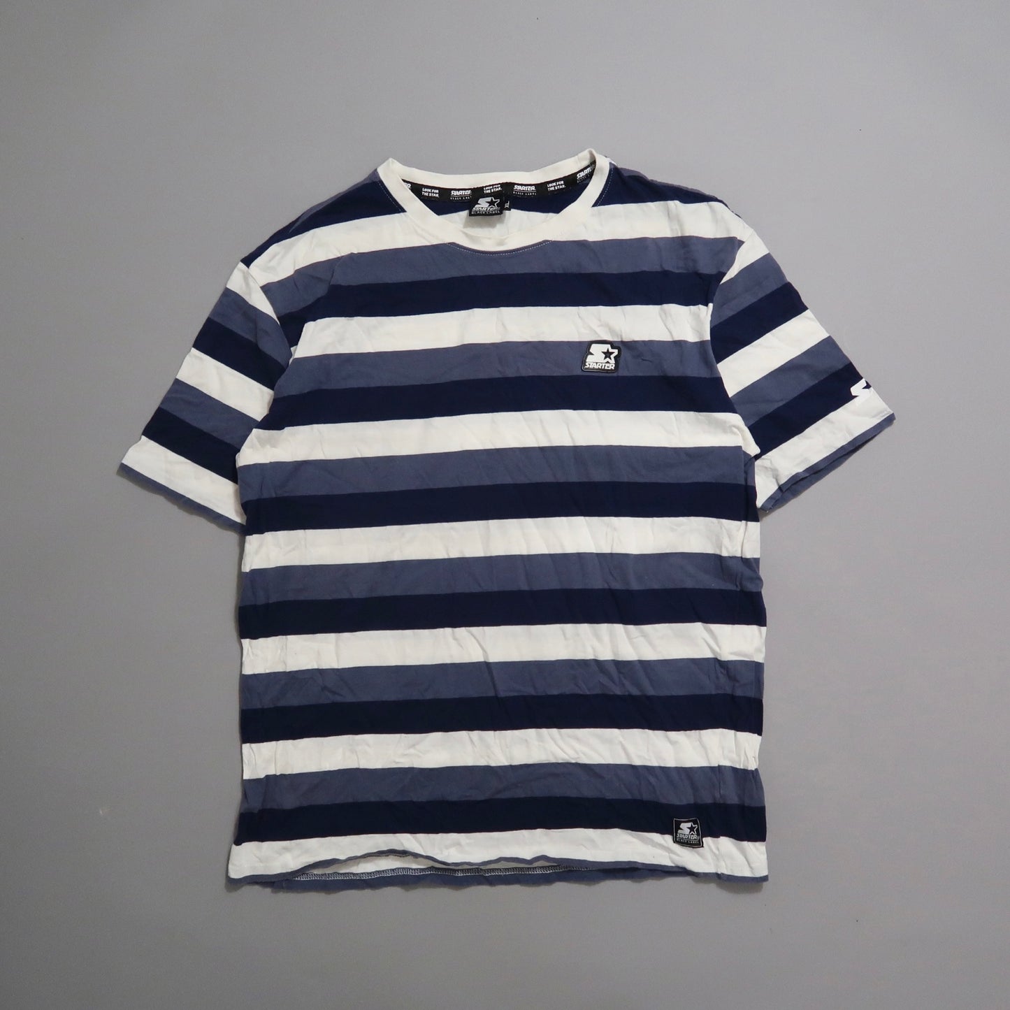 Blue and white striped T-shirt with a small logo on the front.
