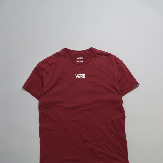 Red Vans t-shirt with logo, laid flat on a gray surface.