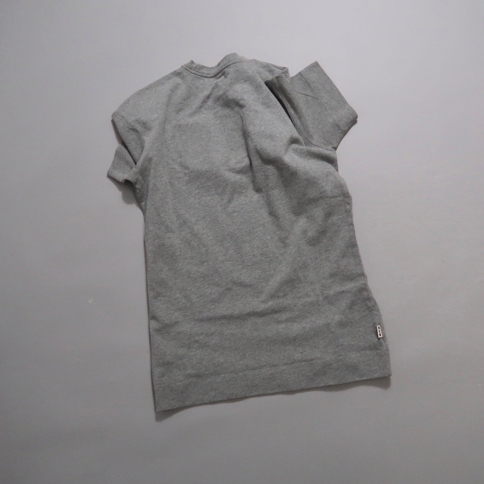 Gray t-shirt lying flat on a plain background.