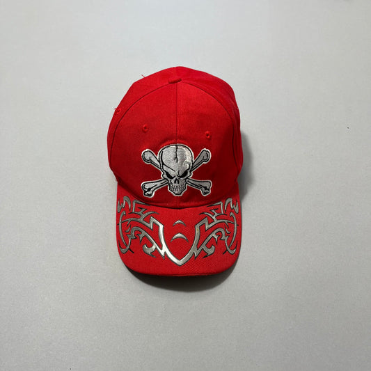 Red cap with skull and crossbones and silver tribal design.