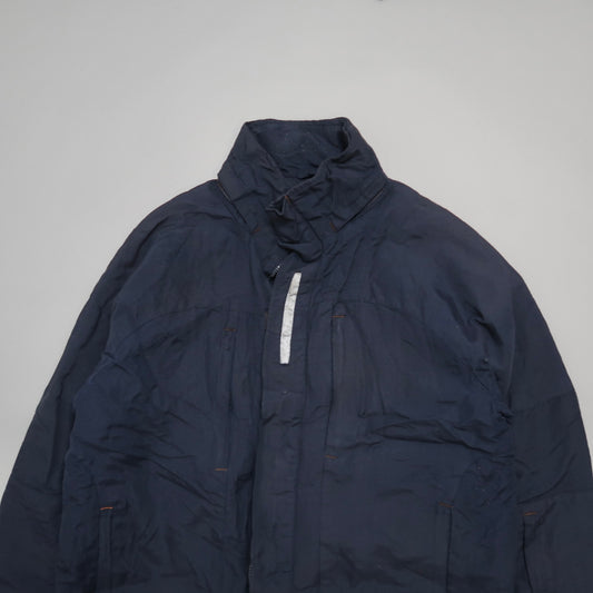 Dark blue jacket with high collar on a light background.