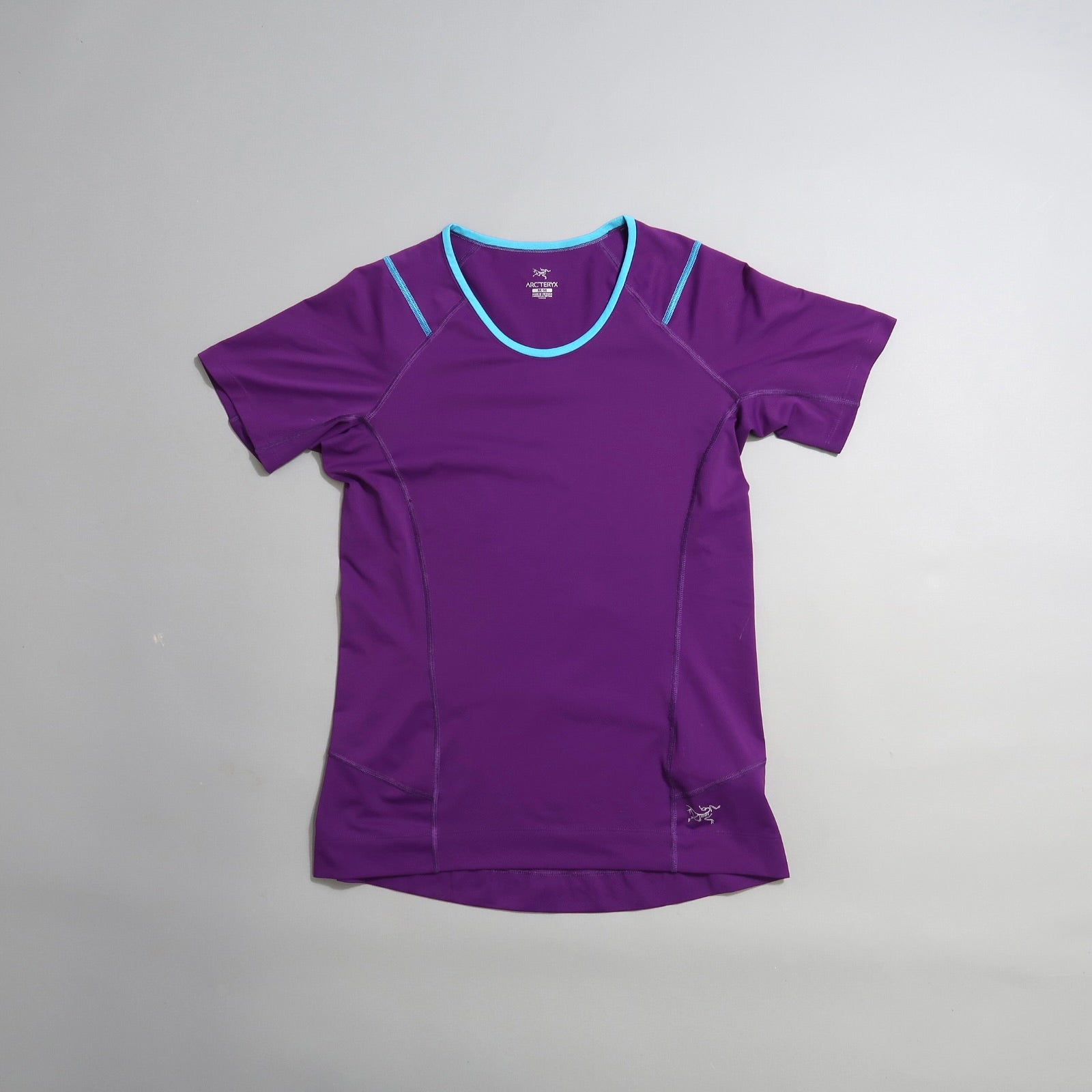 Purple athletic t-shirt with blue trim on a gray background.