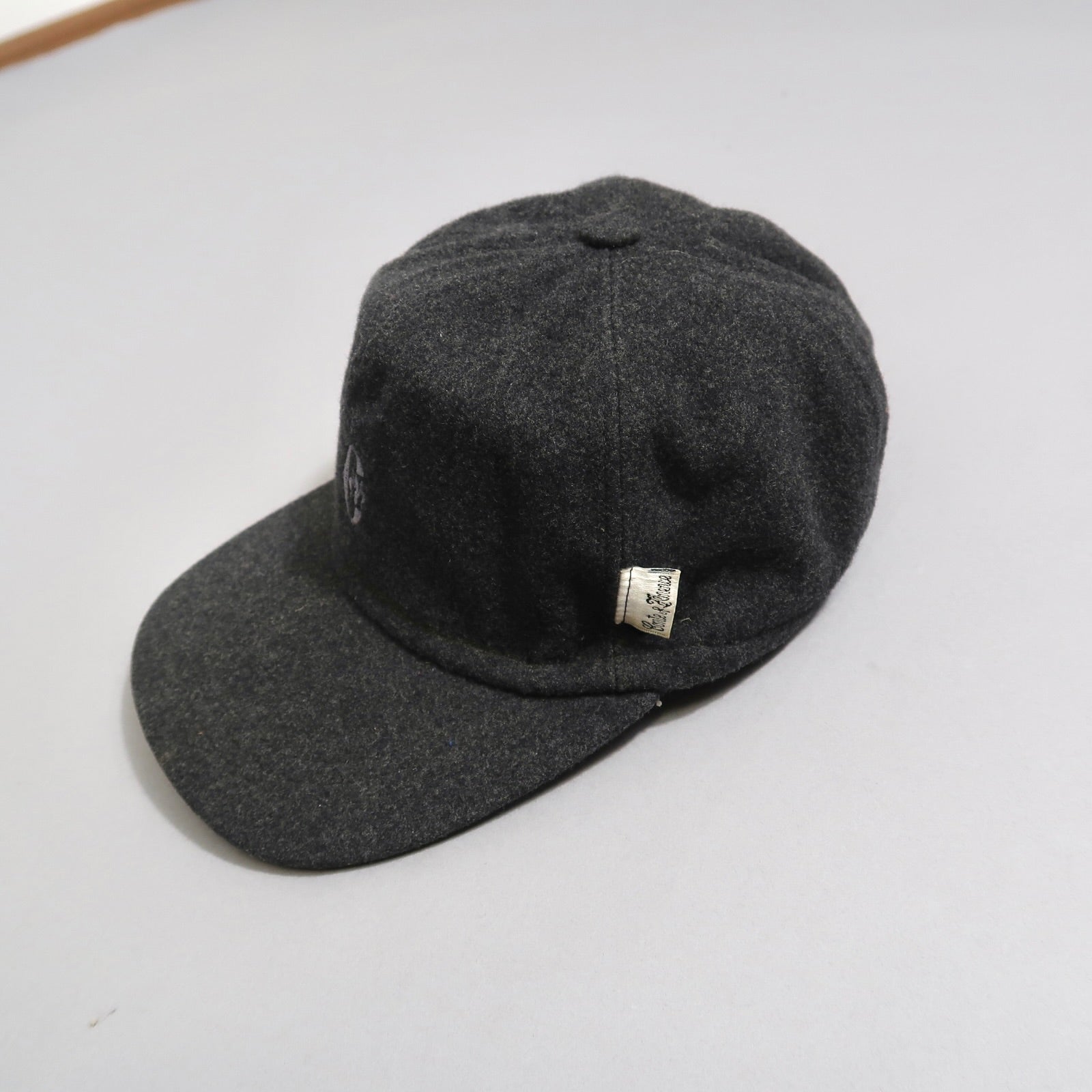Dark gray wool cap with a small tag on the side.