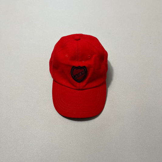 Red cap with embroidered nullASICSnull logo on a neutral background.