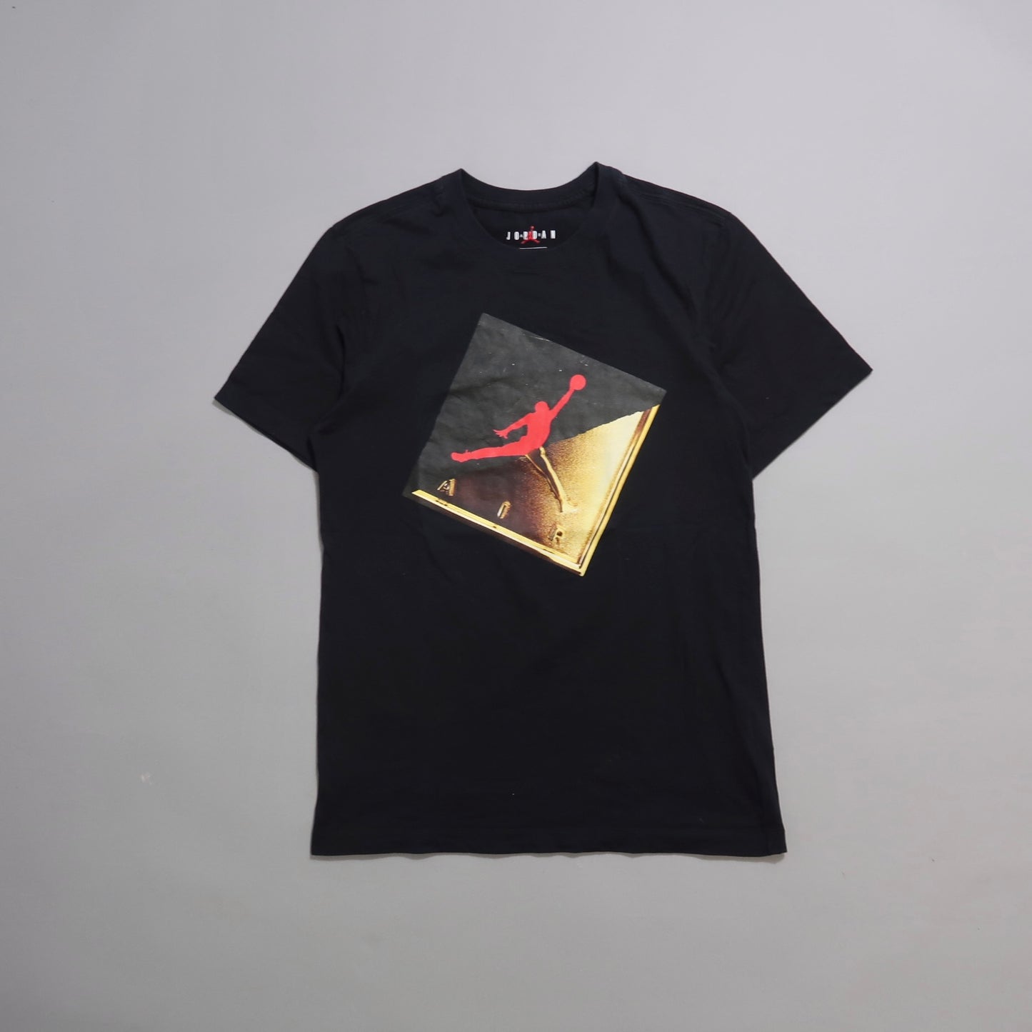 Black T-shirt featuring a red and gold graphic sports logo.