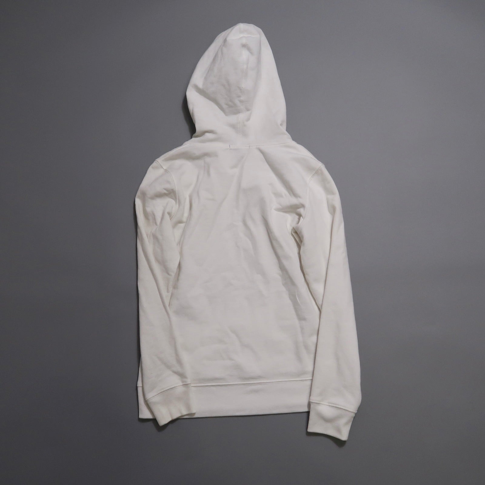 Back view of a plain white hoodie on a gray background.