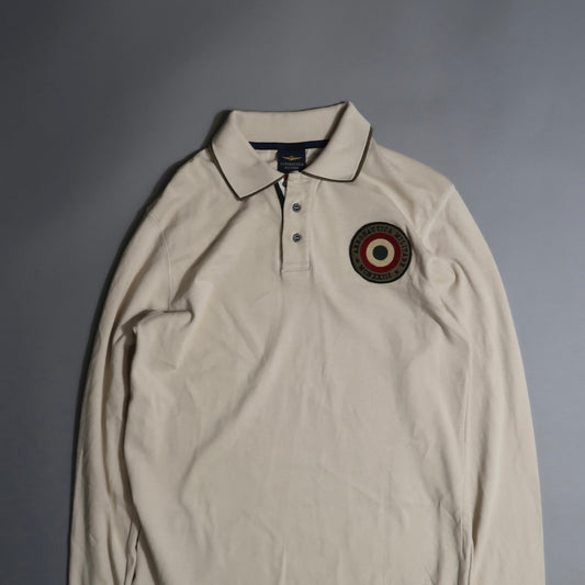 Beige long-sleeve polo with circular embroidered logo on chest.