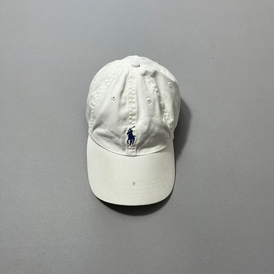 White baseball cap with a blue logo on a gray background.