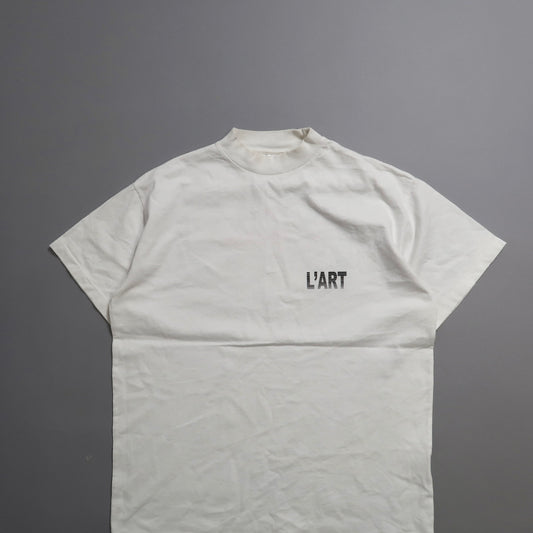 White T-shirt with nullL'ARTnull text on a gray background.