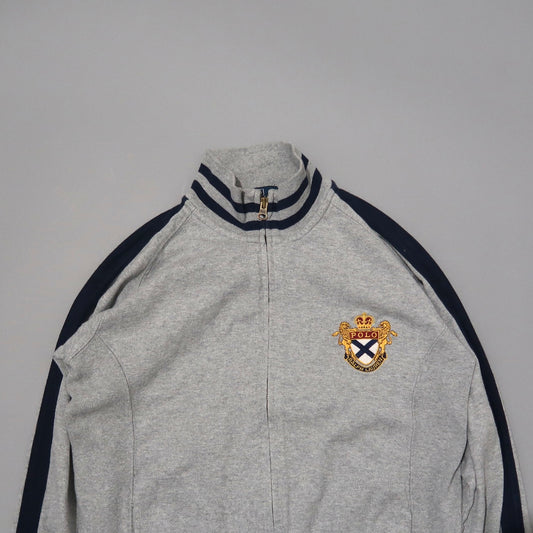 Gray jacket with striped collar and embroidered crest on chest.