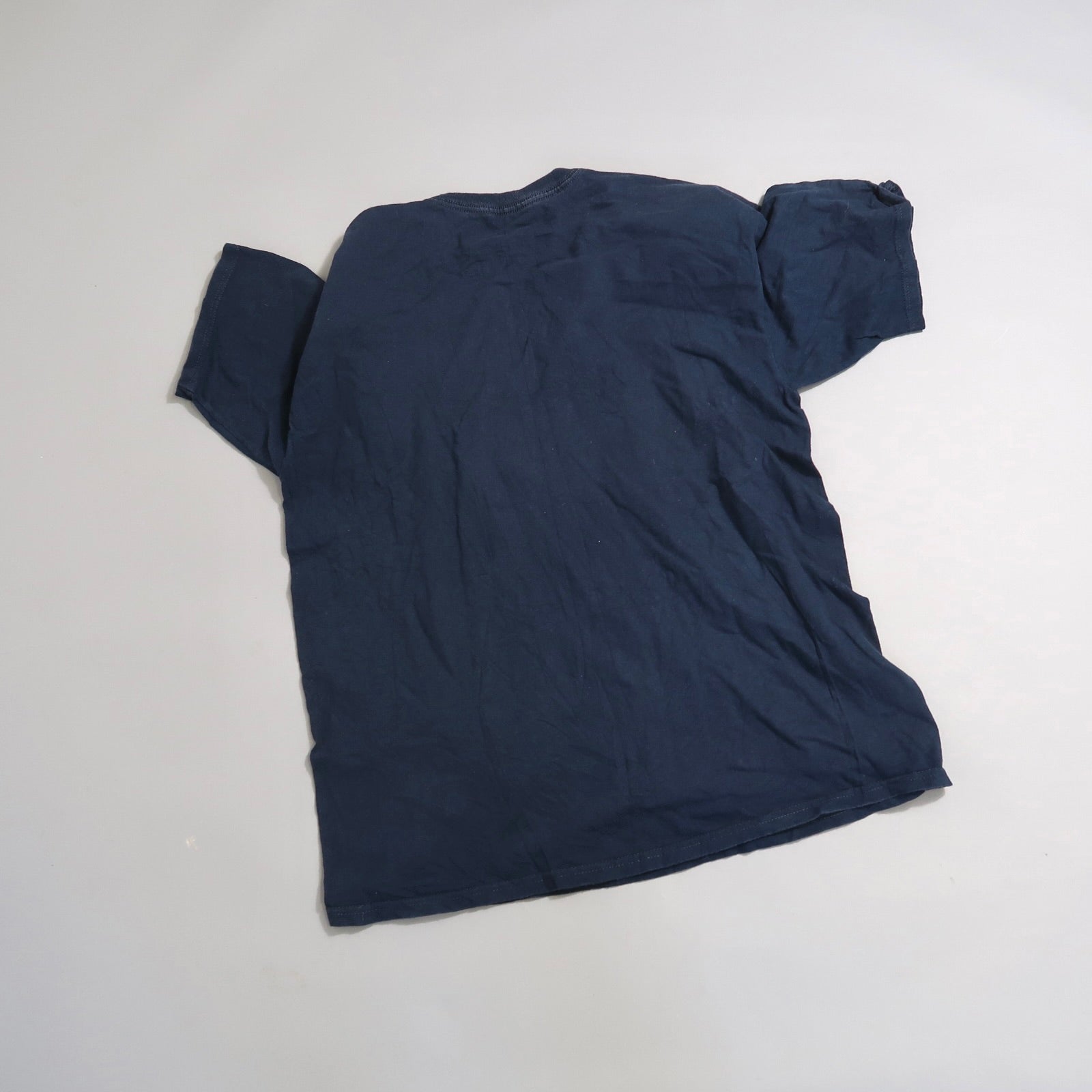 Navy blue T-shirt lying flat, viewed from the back.