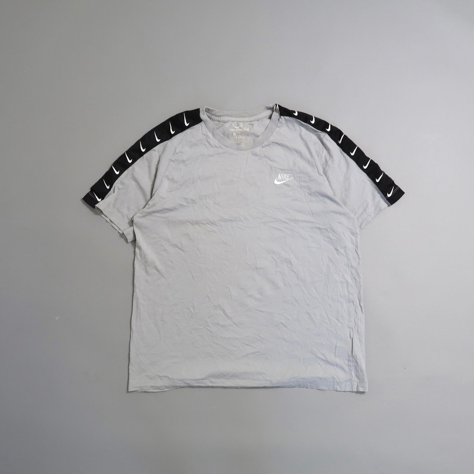 Gray Nike shirt with black sleeve accents featuring white swooshes.