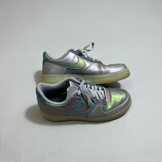 Holographic sneakers with grey laces on a plain background.