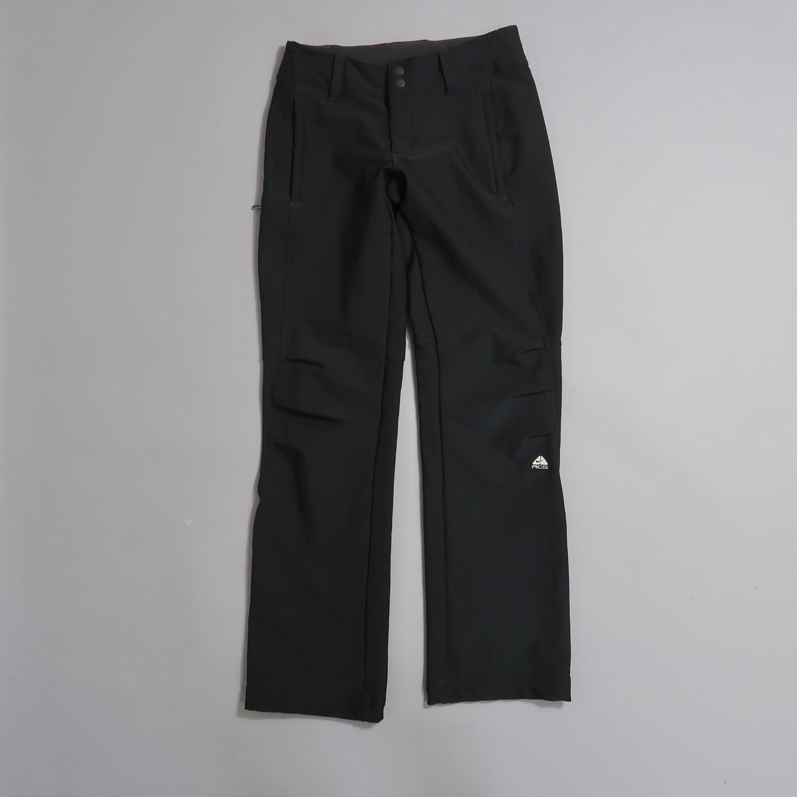 Black pants with pockets and a logo on the left leg.