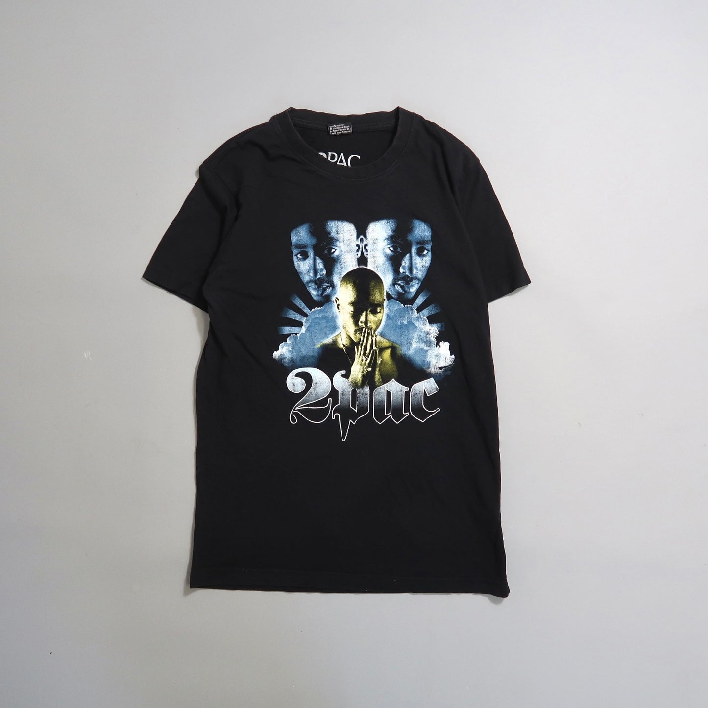 Black T-shirt featuring graphics of a famous rapper and null2Pacnull text.