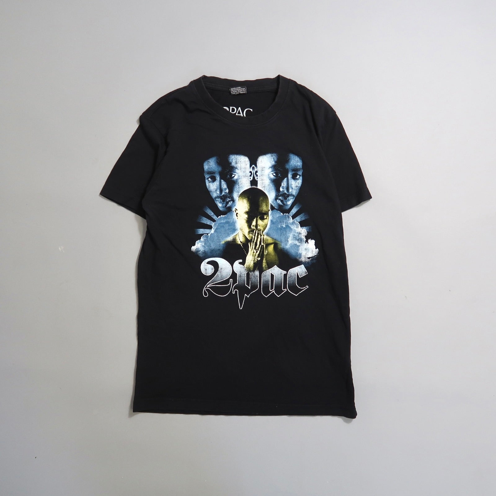 Black T-shirt featuring graphics of a famous rapper and null2Pacnull text.