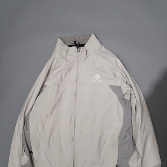White Henri Lloyd zip-up jacket on a gray background.