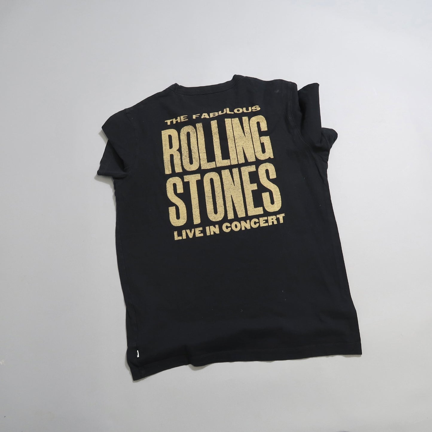 Black Rolling Stones concert t-shirt with gold text.