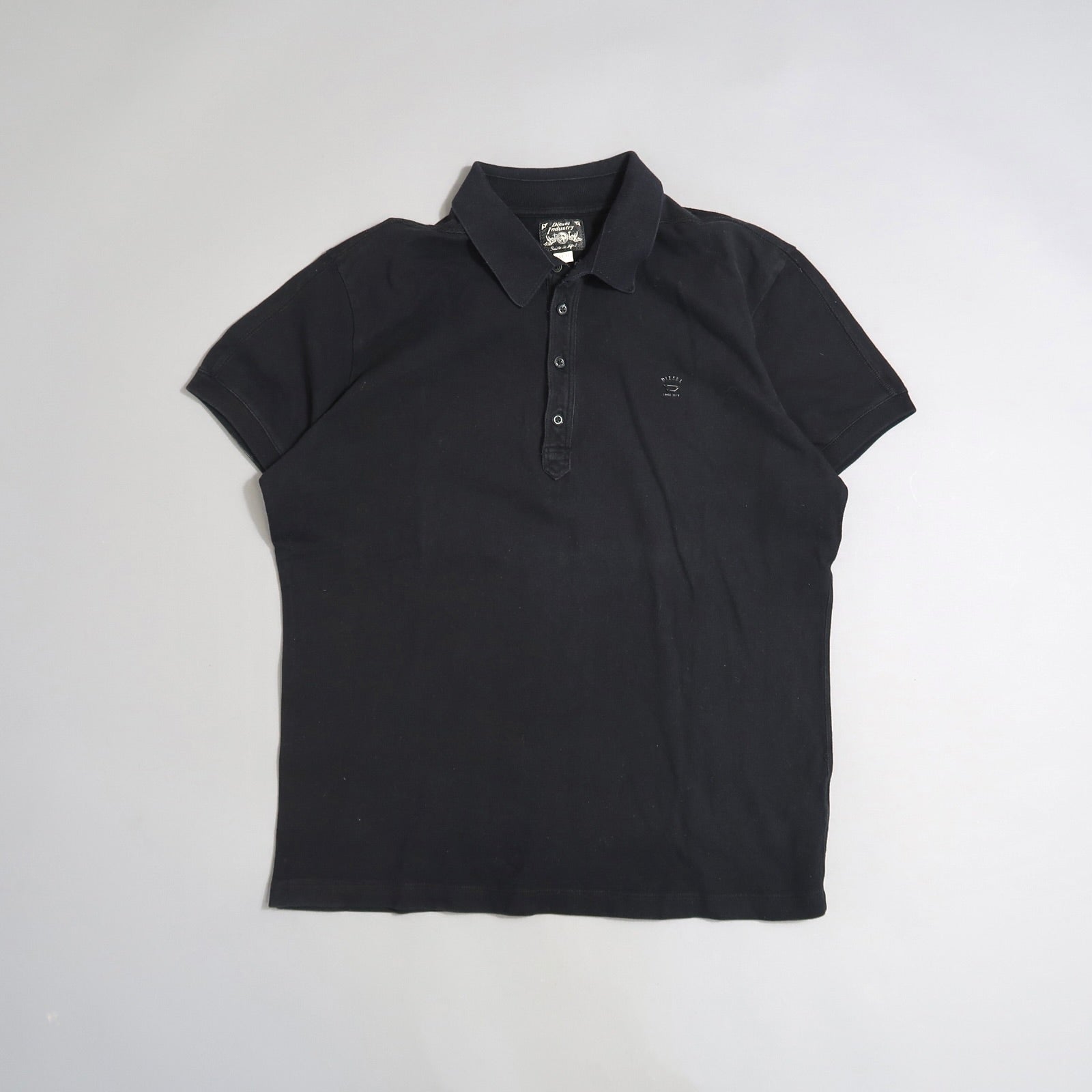 Black polo shirt with collar and short sleeves on a plain background.