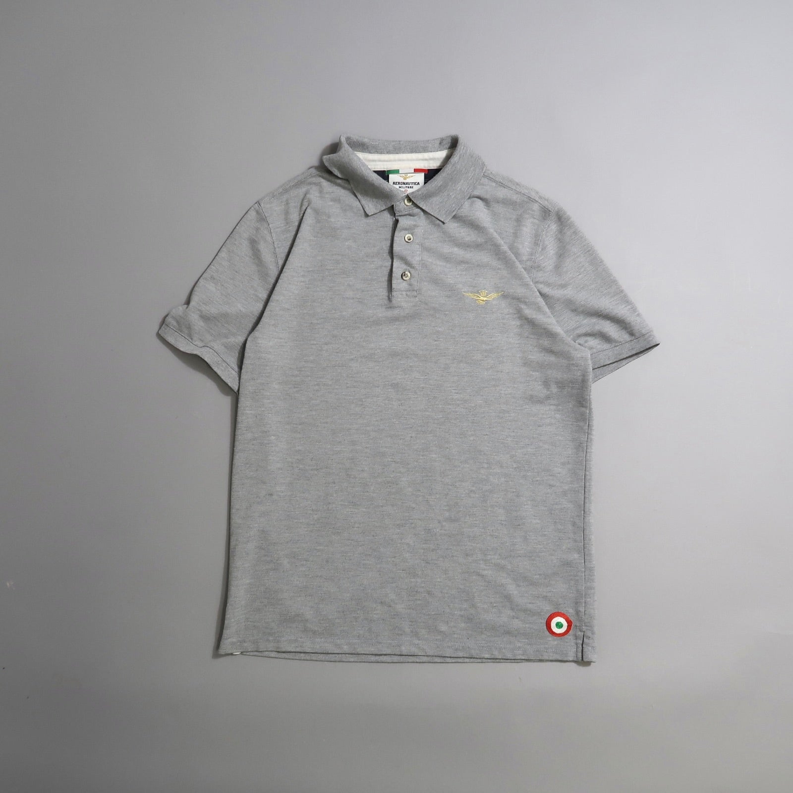 Gray polo shirt with small embroidery and button-up collar.