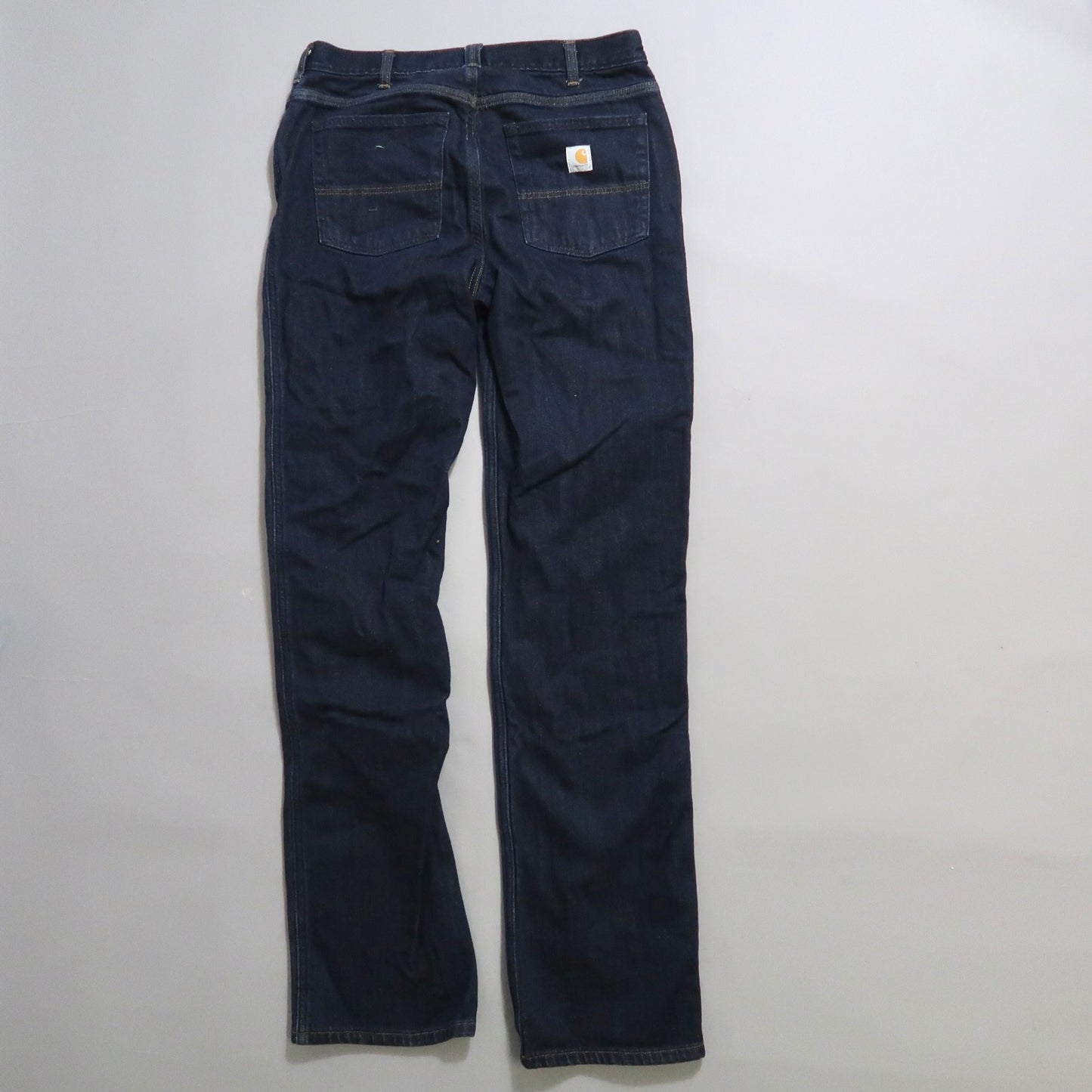 Dark blue jeans lying flat, with rear pockets visible.