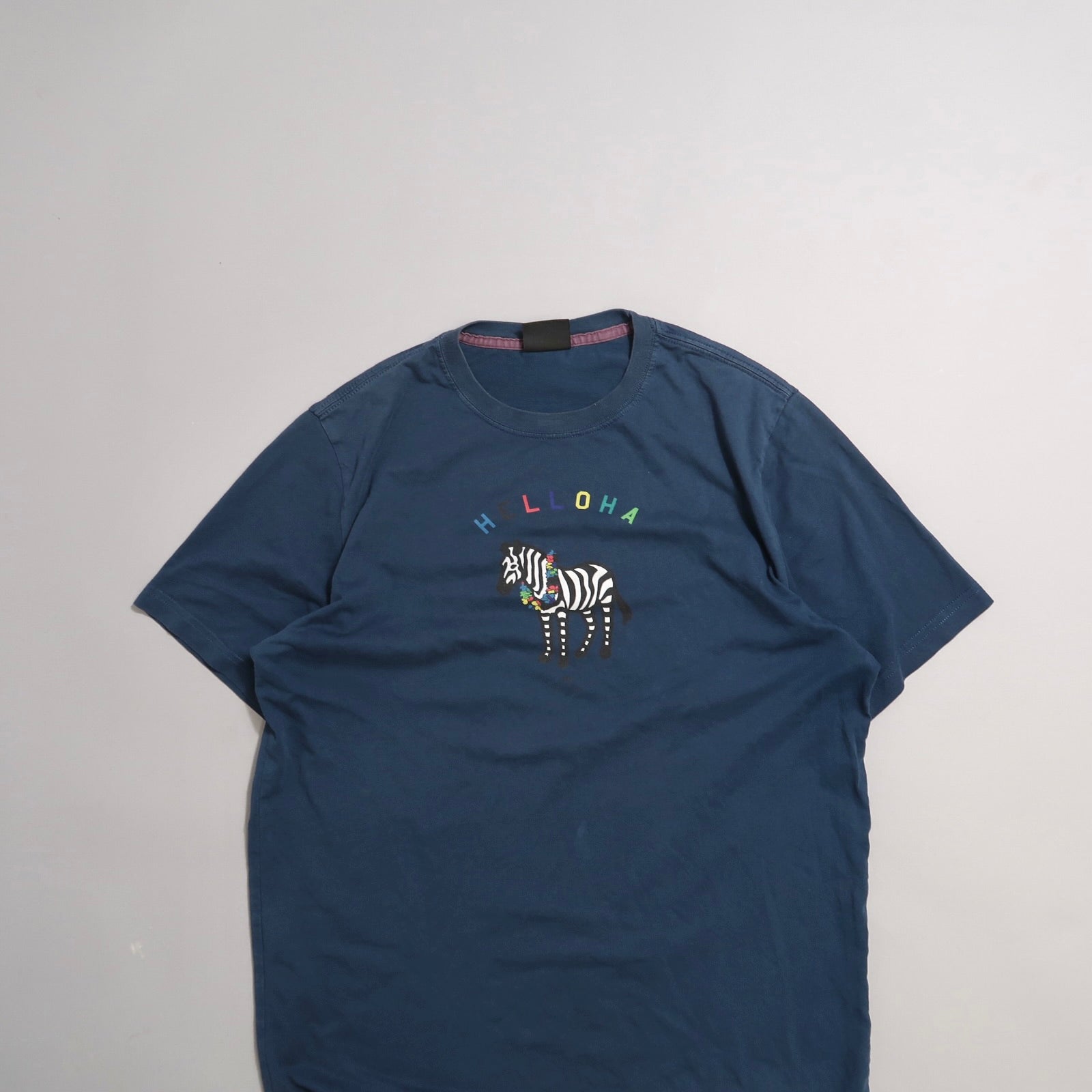 Navy blue shirt with zebra and nullHLLLOHAnull text design.