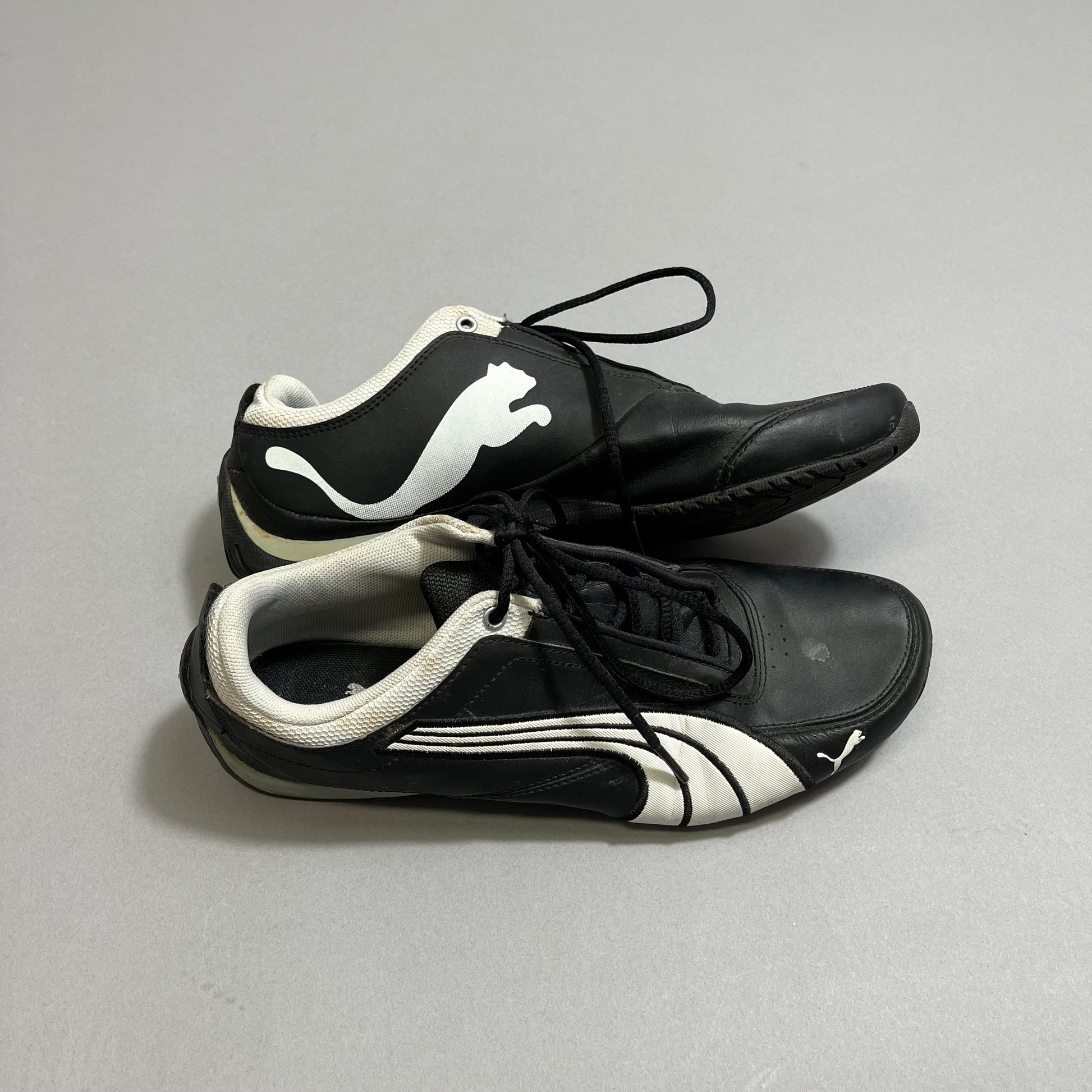 Black and white sports shoes with a pouncing cat logo.