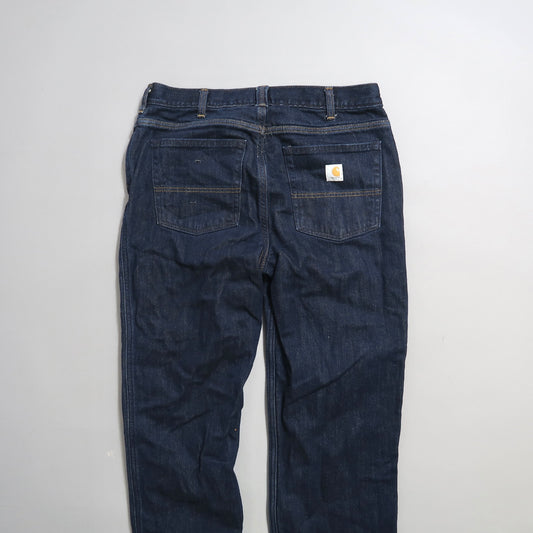 Back view of dark blue jeans with a logo on the pocket.