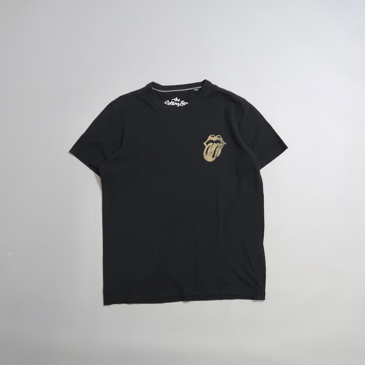 Black T-shirt with tongue logo on front, laid flat.