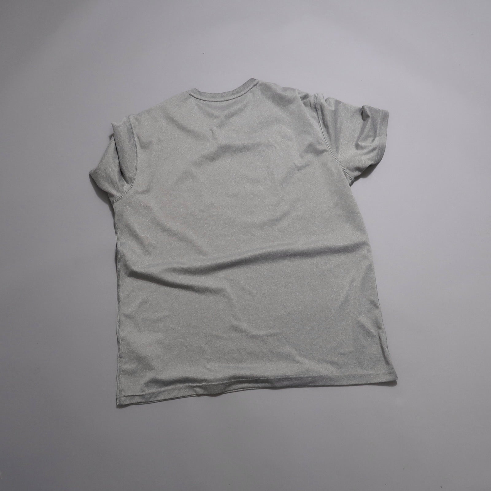 Gray T-shirt laid flat, viewed from the back.