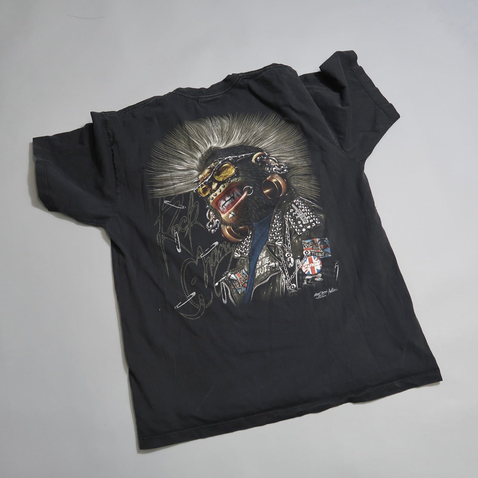 Black T-shirt with punk-style graphic design on the back.