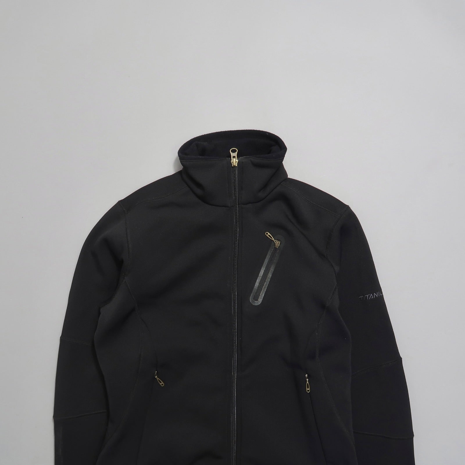 Black zip-up jacket with high collar and multiple pockets.