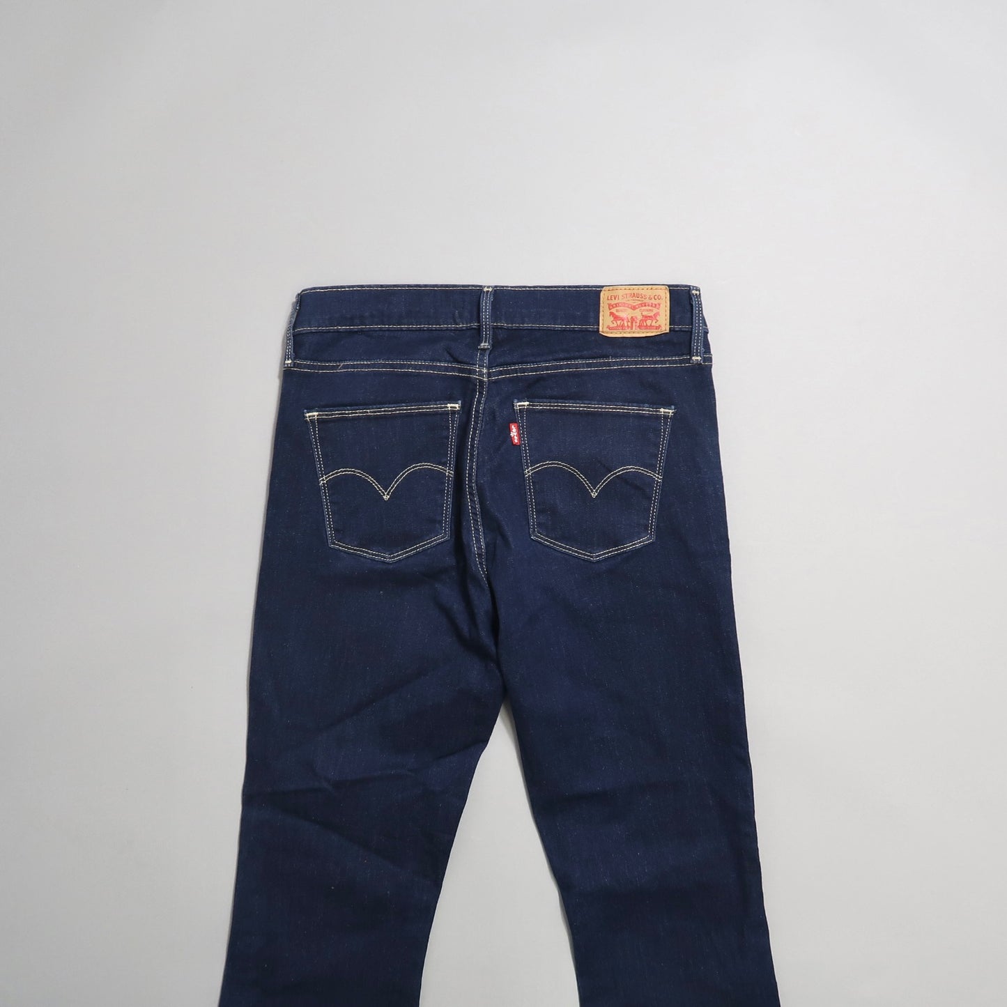 Back view of dark blue jeans with contrasting stitching.