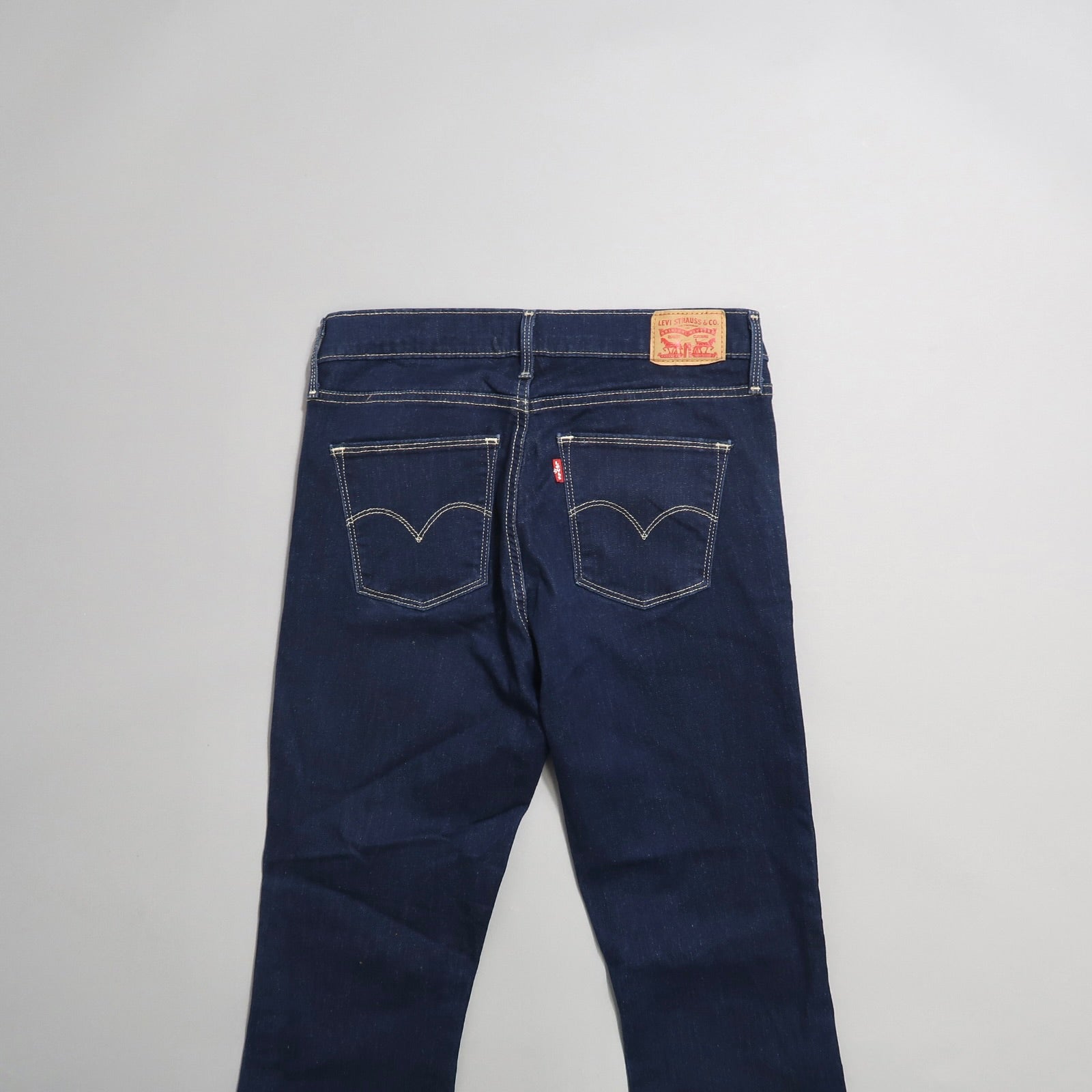Back view of dark blue jeans with contrasting stitching.