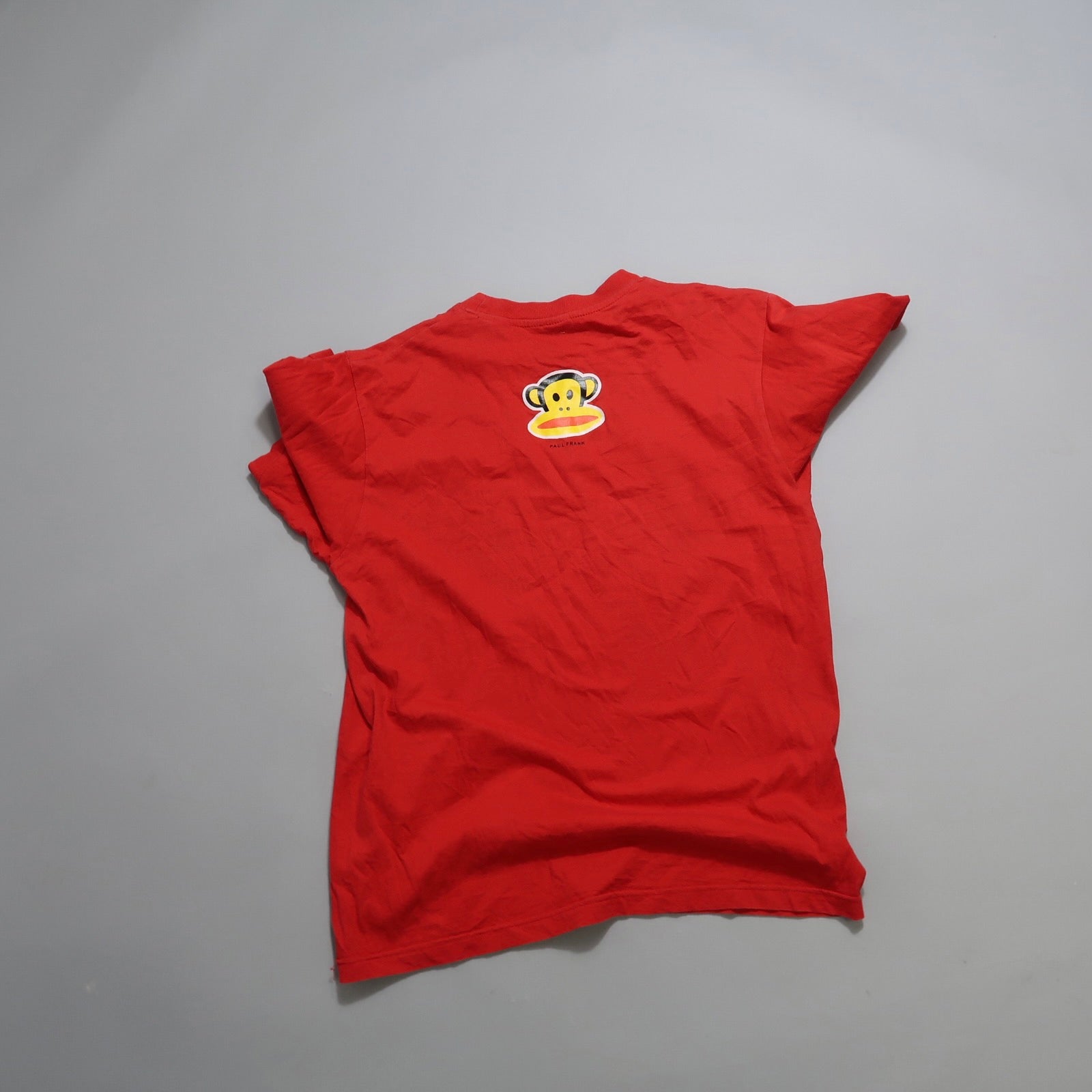 Red T-shirt with a monkey face logo on the back.
