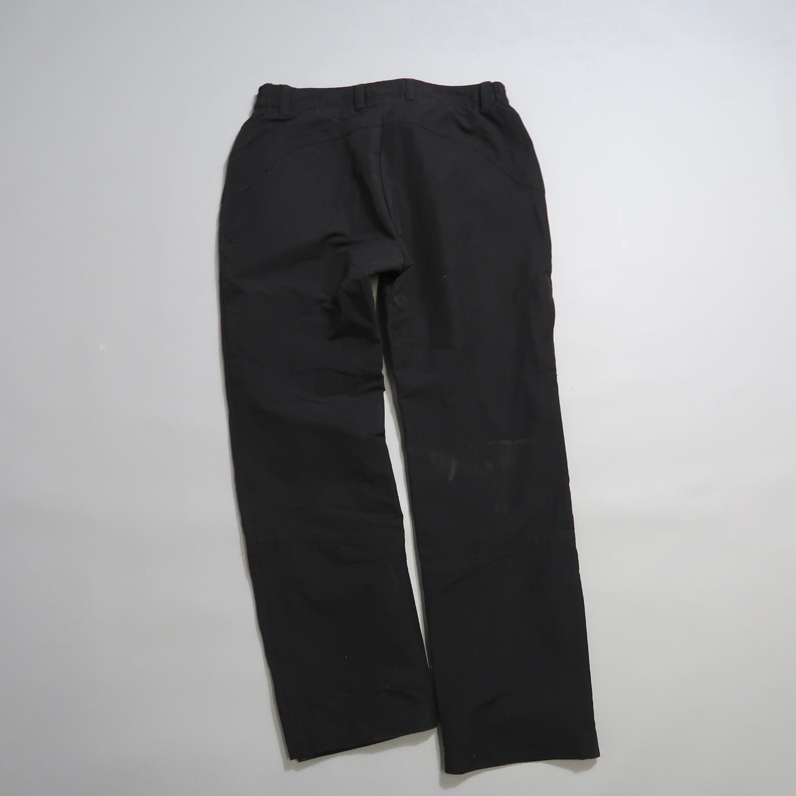 Black pants laid flat on a plain white background.