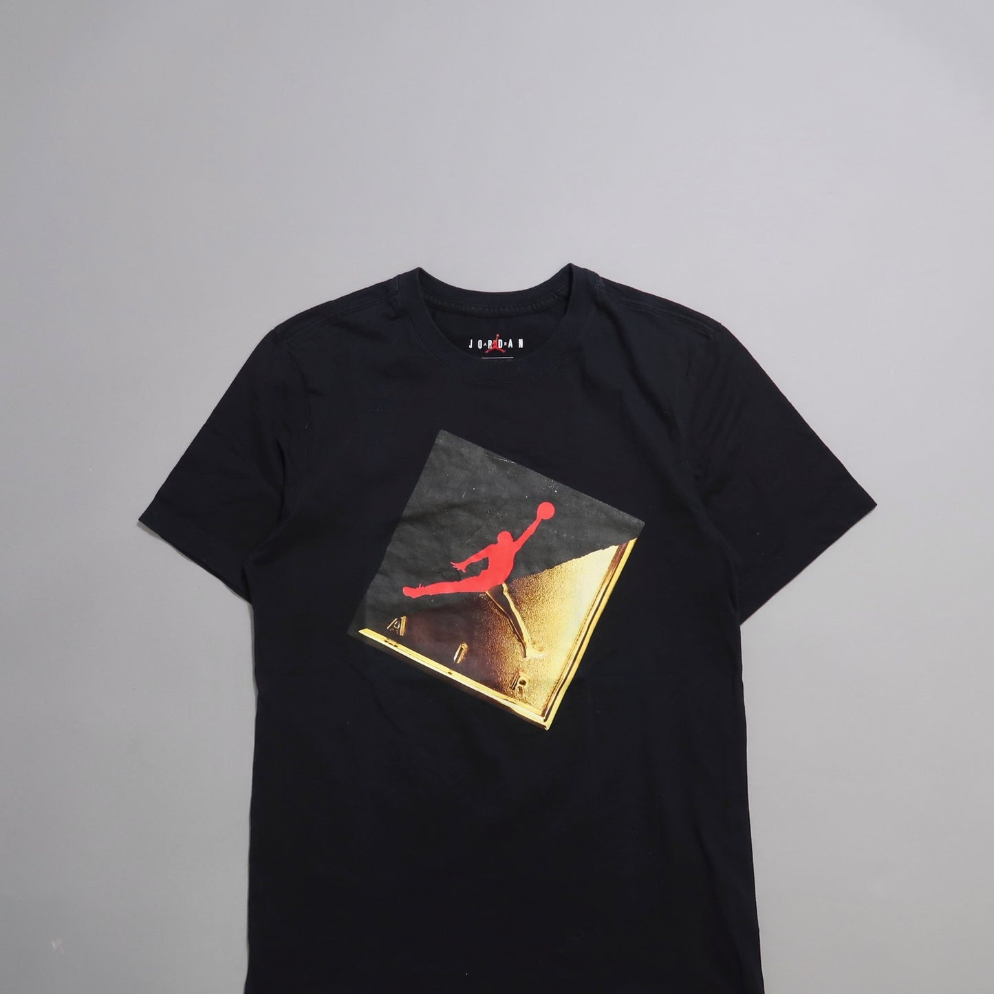 Black t-shirt with red and gold Jumpman logo graphic.