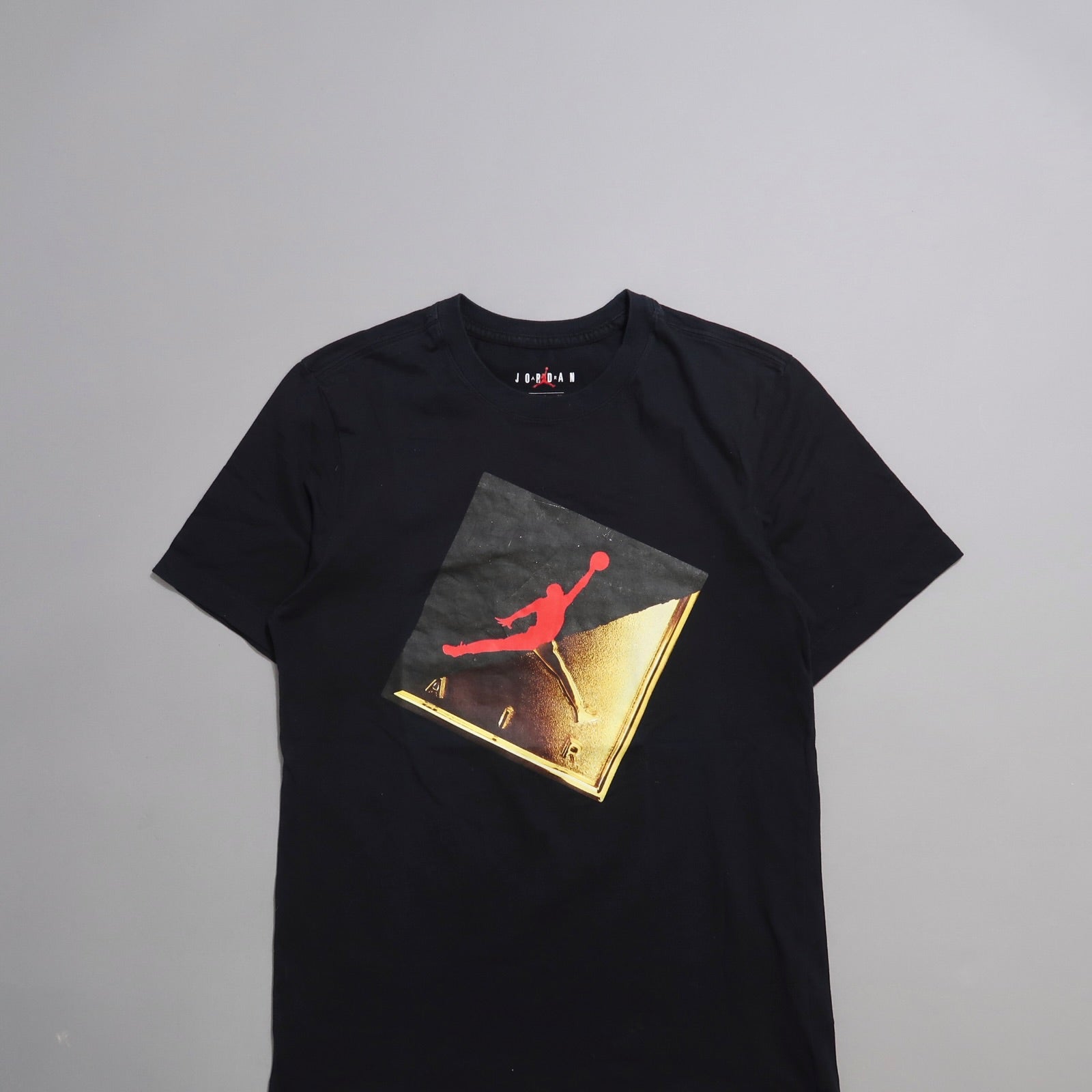 Black t-shirt with red and gold Jumpman logo graphic.