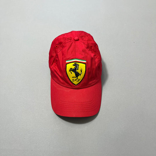 Red cap with a Ferrari logo on a neutral gray background.