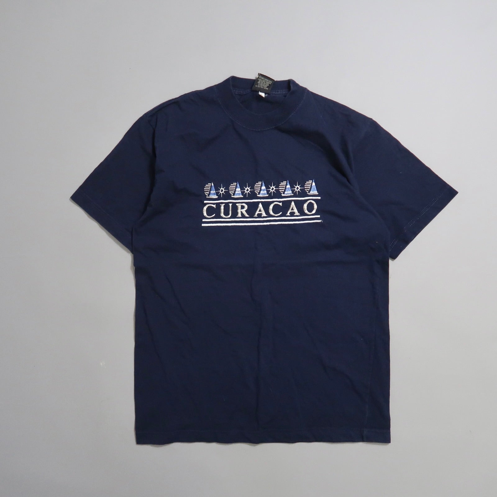 Navy blue T-shirt with nullCuraçaonull and sailboat graphics.
